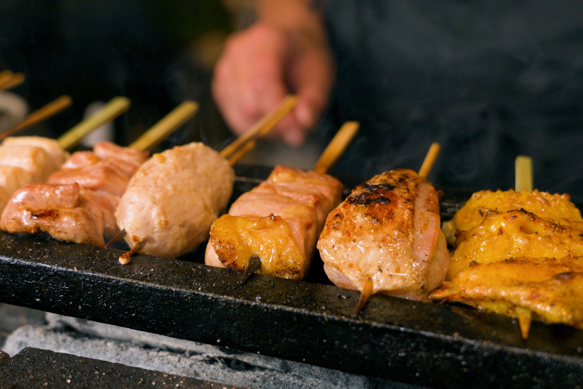 Yakitori skewers grilling over white-binchotan charcoal at Hotori