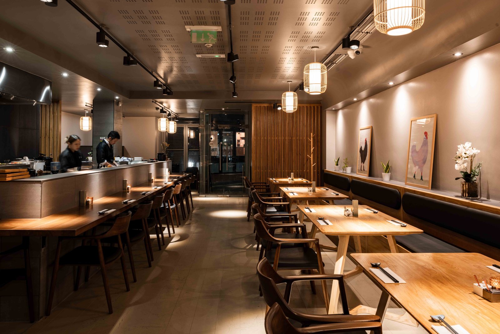 Hotori interior at dusk — counter, pendant lights, and dining room set for service